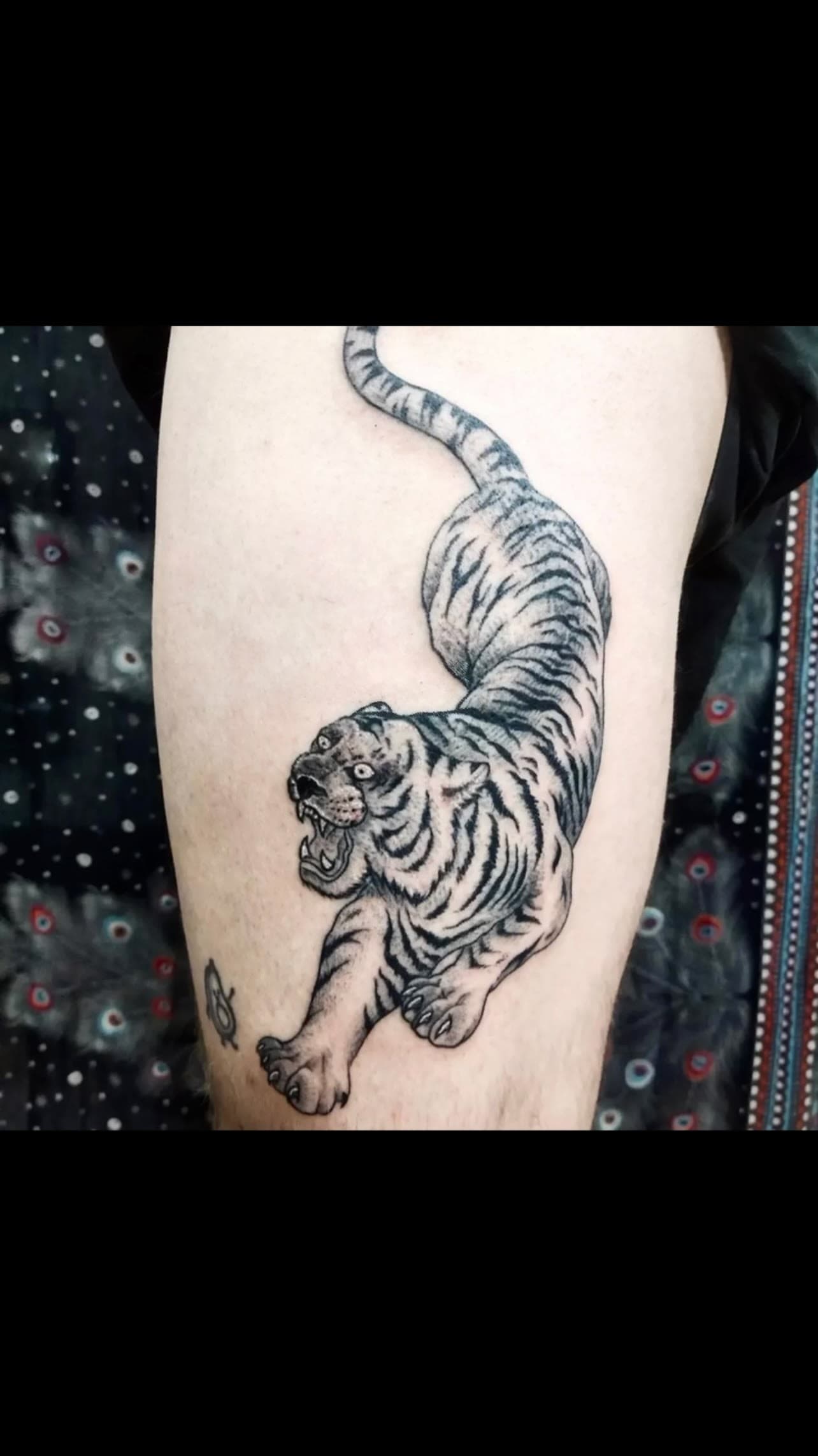 Crawling tiger tattoo on the thigh