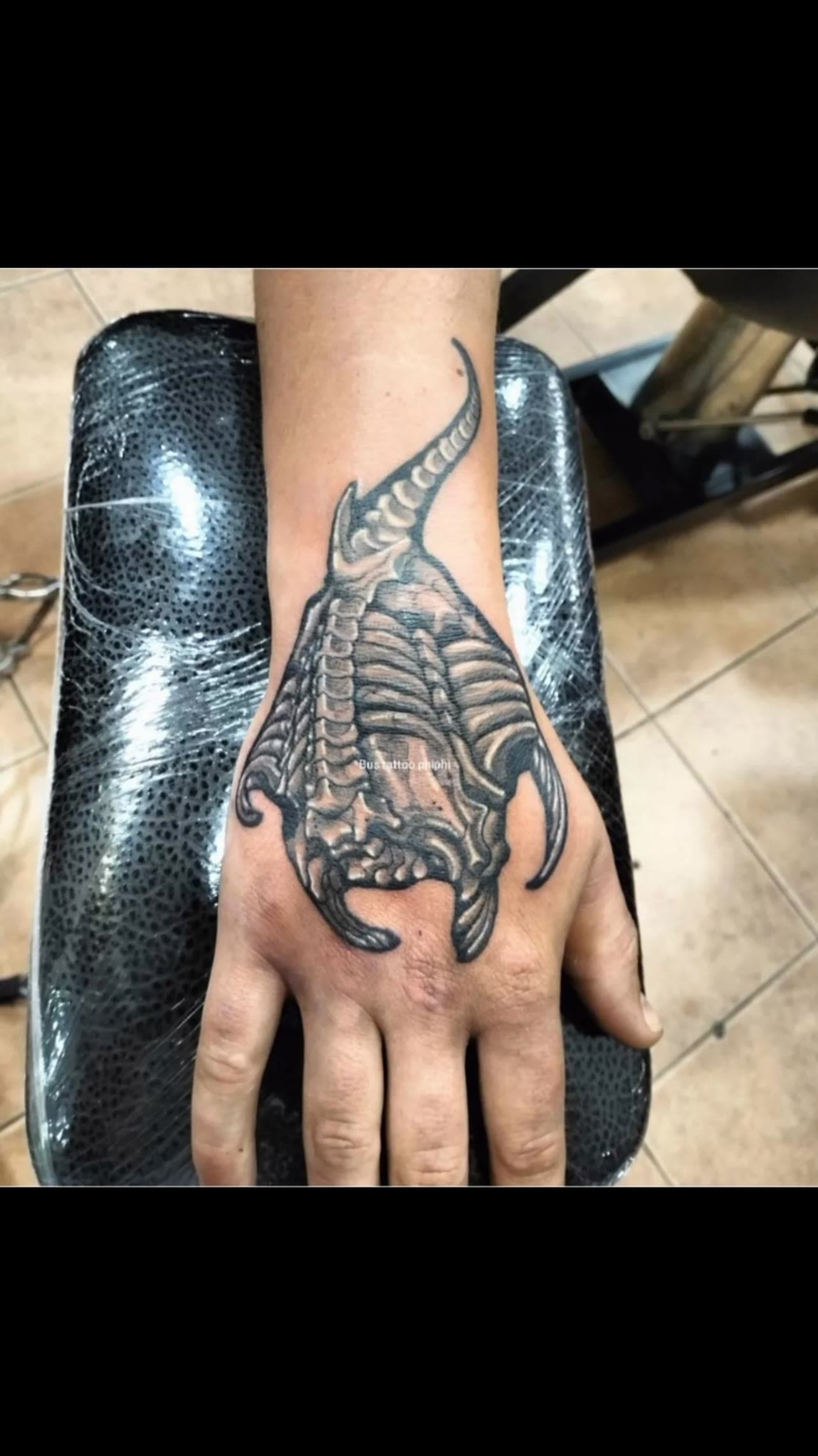 Black and grey tattoo on the back of the hand